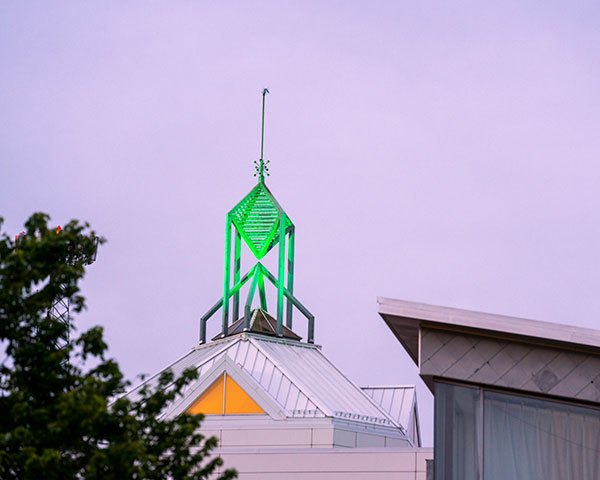 The spire on Mason's Fairfax campus lit up green. 